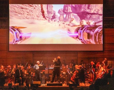 Orchester auf der Bühne mit Leinwand im Hintergrund, Fotocredit Highlight-Concerts